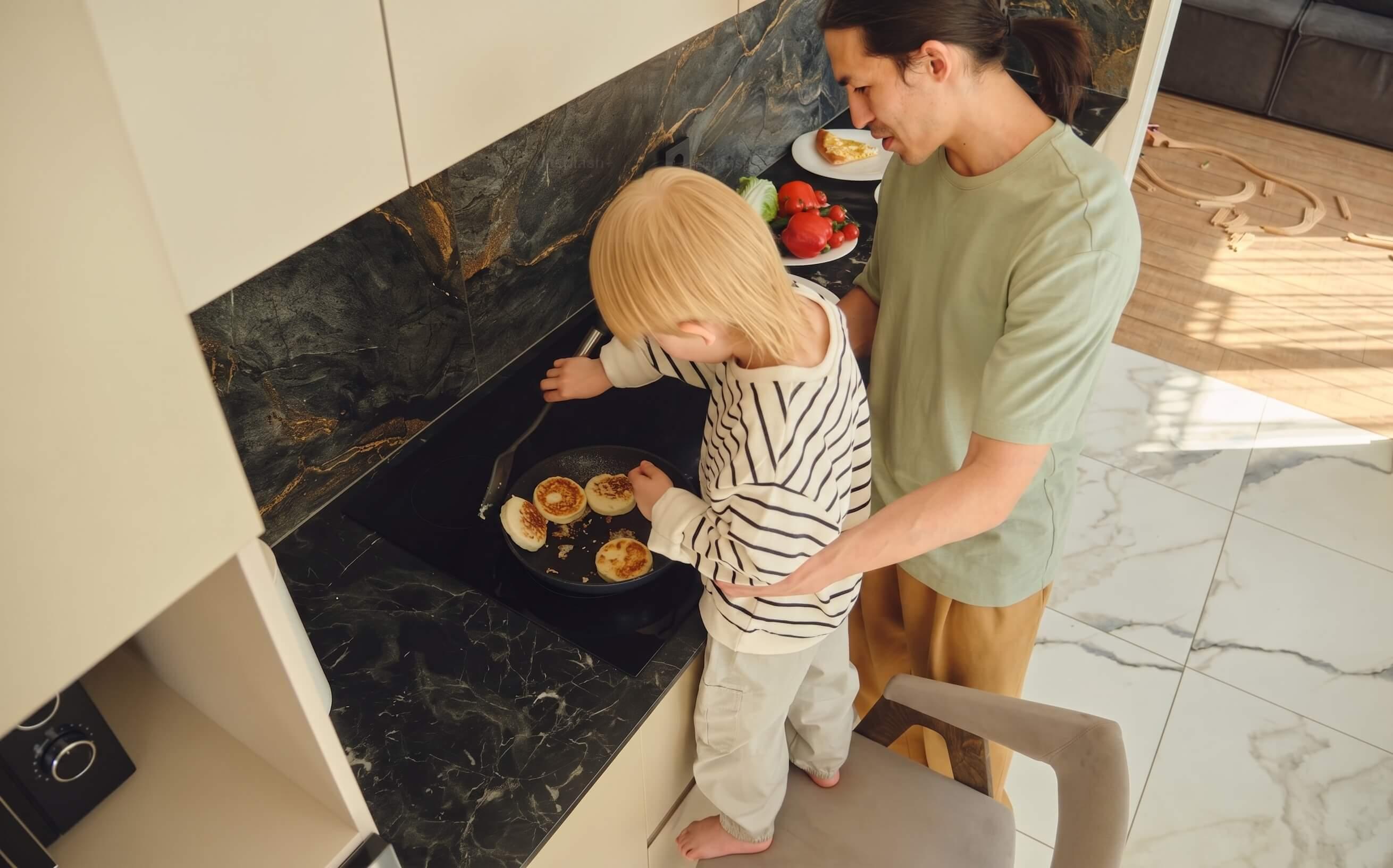 A parent and child cooking together on an induction cooktop.